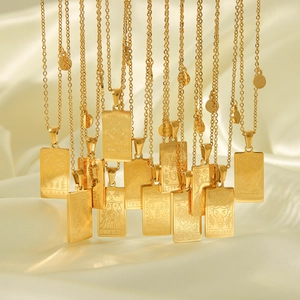 Colliers zodiaque dorés avec pendentifs rectangulaires sur un élégant fond de soie beige
