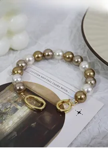 Detail of multi-color pearl necklace with champagne beads and gold oval clasp closure