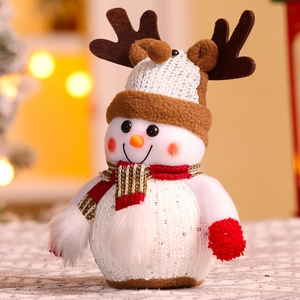 Detail of Christmas snowman plush with knit hat and striped scarf in warm holiday lights