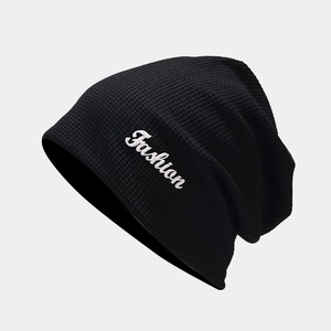 Détail du bonnet en maille gaufrée noire avec broderie Fashion et tissu texturé