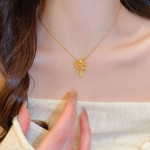 Detailed close-up of a gold-plated palm tree pendant on a delicate necklace for women
