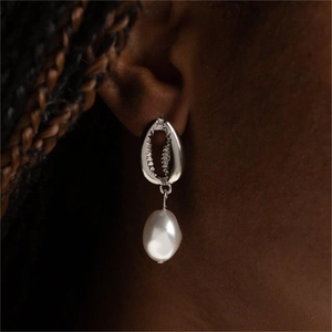 Boucle d'oreille en acier inoxydable en forme de coquillage avec perle blanche sur mannequin