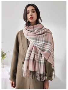 Detail of pink and grey plaid scarf with long fringe tassels and soft texture