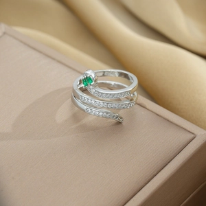 Detail of silver snake ring featuring green gem eyes and sparkling pavé crystals