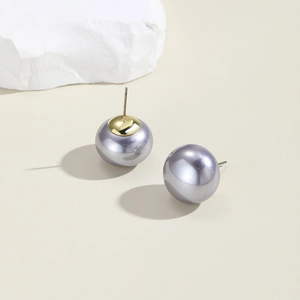 Macro detail of elegant grey-purple pearl earrings with high metallic luster on a beige base