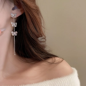 Détails de boucles d'oreilles nœud à pampilles en zircon portées par un mannequin