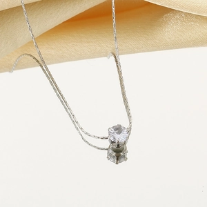 Détail d'un collier en acier inoxydable argenté avec zircon et sertissage à six griffes