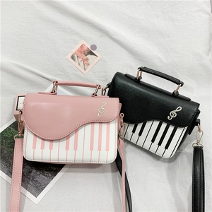 Pink and black piano-themed handbags with musical notes and keyboard print pattern
