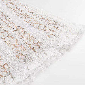 Detail of white floral lace fabric with delicate eyelash trim and sheer mesh texture