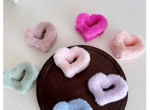 Pinces à cheveux en peluche en forme de cœur de diverses couleurs sur plateau.