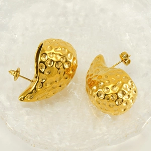 Macro detail of 18K gold-plated stainless steel earrings with hammered texture