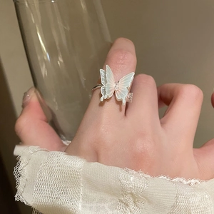 Elegant butterfly ring with faux pearls and gold plating shown on model's hand