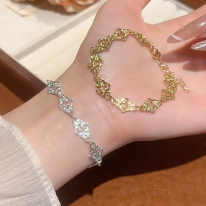 Detail of filigree lace-textured bracelets in gold and silver finish with lobster clasp