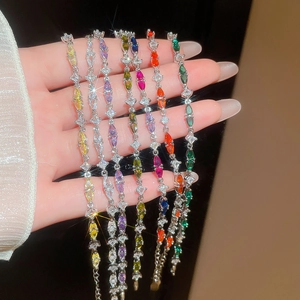 Macro detail of pear-cut colorful zircon bracelets held in hand with shimmering accents
