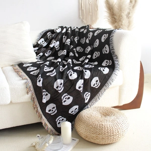 Detail of bohemian skull woven blanket with colorful tassels on a white sofa