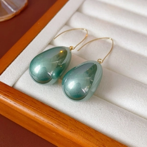 Dettaglio di orecchini vintage francesi con perle a goccia verde scuro e ganci d'oro