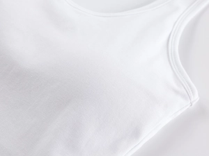 Close-up of white ribbed knit fabric texture and high-quality stitching on the tank top