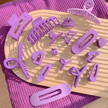 Flat lay of purple matte resin hair clips and floral hairpins on a wooden tray