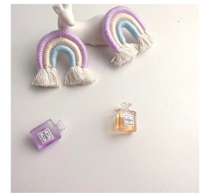 Close-up of handmade woven rainbow tassels in purple and blue tones for accessories