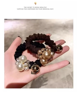 Detail of luxury fabric hair scrunchies with white pearls and gold metal beads