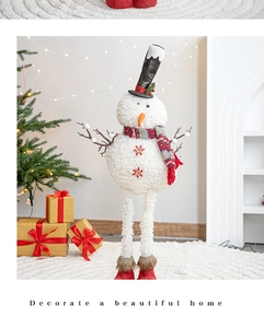 Long-legged Christmas snowman doll with red boots and plaid scarf in a cozy festive setting