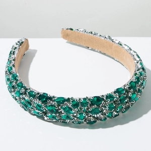 Macro detail of luxury emerald crystals on silver frame with soft velvet lining