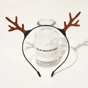 Close-up of brown plush reindeer antlers on a black headband for Christmas party