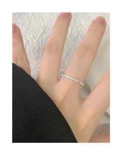 Detailed view of a minimalist S925 sterling silver beaded ring on a female finger