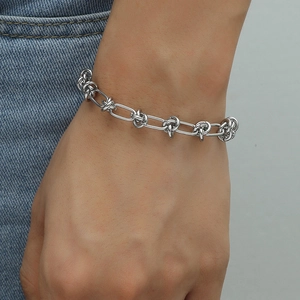 Men's silver link chain bracelet with knot design detail in industrial minimalist style