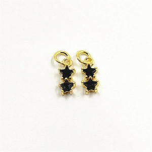 Macro view of double star pendants with gold frames and black cubic zirconia stones
