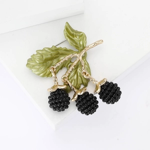 Chic gold alloy blackberry brooch with green enamel leaves and black beads on white stand