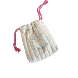 Quilted cotton drawstring pouch with pink cord and label on white background