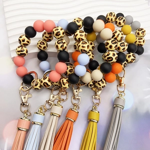 Detailed macro of leopard print silicone beads and colorful tassels on keychain rings