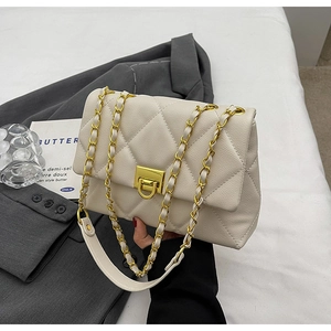 Detailed view of beige quilted leather mini bag with gold chain and turn-lock closure