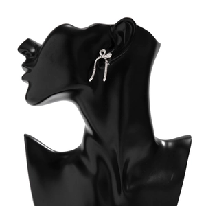 Detail of silver bow earrings with micro-pave crystals on a black silhouette model
