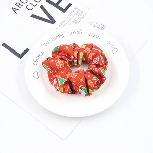 Detail of red Christmas scrunchie with festive patterns on a white decorative plate