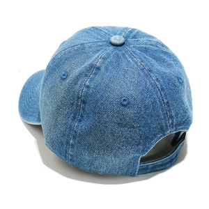 Detail of adjustable metal buckle and washed denim texture on blue baseball cap