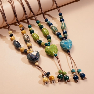 Détail de colliers de perles en céramique avec pendentifs en cœur sur cordes tissées
