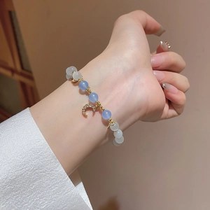 Detailed shot of beaded bracelet with cat eye stones and sparkling crescent moon charm