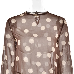 Détail de la robe en maille transparente marron à pois blancs avec col rond élégant