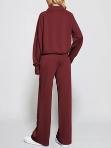 Rear view of woman in burgundy two-piece tracksuit with half-zip top and wide-leg pants