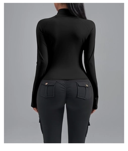 Détail du legging de sport avec poches cargo à boutons dorés et effet froncé aux fesses
