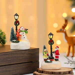 Luminous Christmas resin ornaments featuring Santa and Snowman in a warm winter street scene