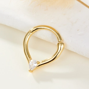 Gros plan d'un anneau de nez en argent S925 doré avec zircon goutte sur pierre