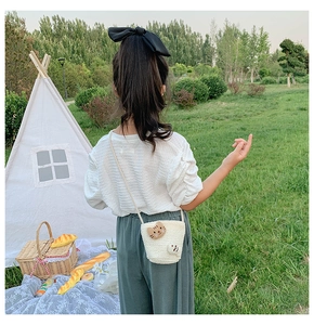 Outdoor-Aufnahme einer Kinder Strohtasche mit Katzen-Patch auf einer Garten-Picknick-Szene