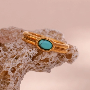 Detailed shot of 18K gold plated stainless steel ring with oval turquoise on coral stone
