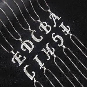 Silver letter pendants necklace with sparkling rhinestones on a textured black background