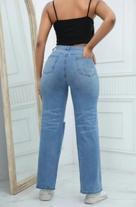 Vista posteriore di jeans denim azzurri a vita alta e gamba larga per donna in studio