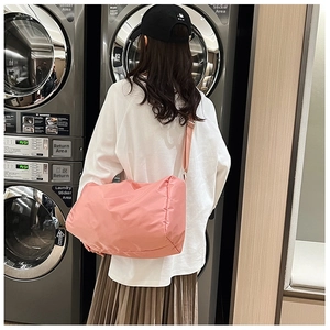 Borsa sportiva rosa in nylon impermeabile con tracolla larga in una moderna lavanderia
