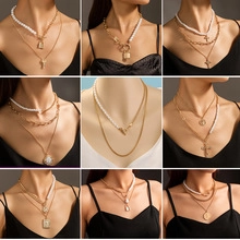Detailed macro view of layered gold chain necklaces with faux pearls and lock charms